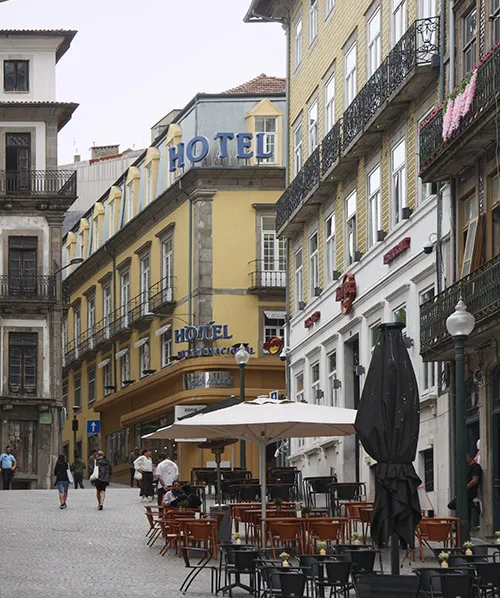 street view of a hotel and outdoor cafe in a historic district with cobblestone pavement and vibrant architecture